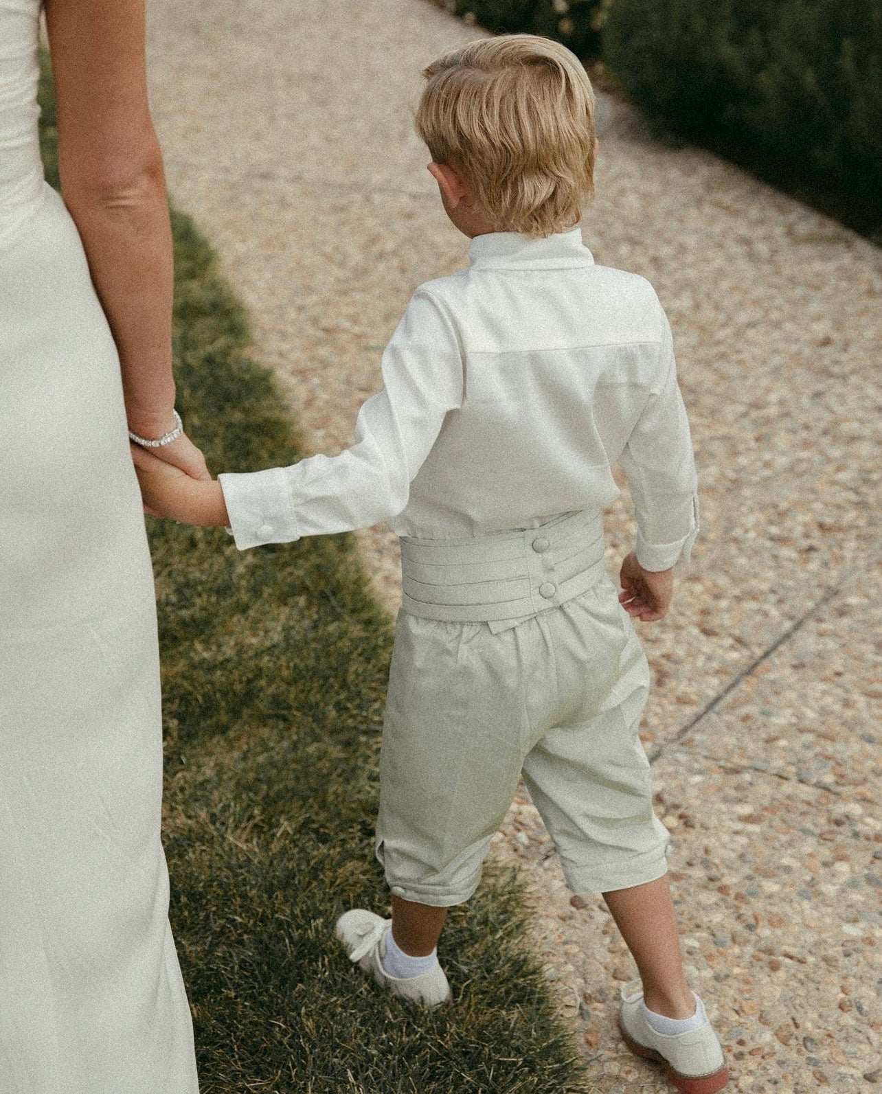 Classic Page Boy Cummerbund and Shirt Set – Handmade in Brooklyn with royal-inspired craftsmanship. The cummerbund features a pleated satin design, covered button closure, and optional personalized embroidery, available in six colors or custom fabric matching. Paired with the traditional Royal Page Boy Shirt, made from luxurious Italian cotton in eggshell white or custom colors, featuring covered buttons and a smart Peter-pan collar