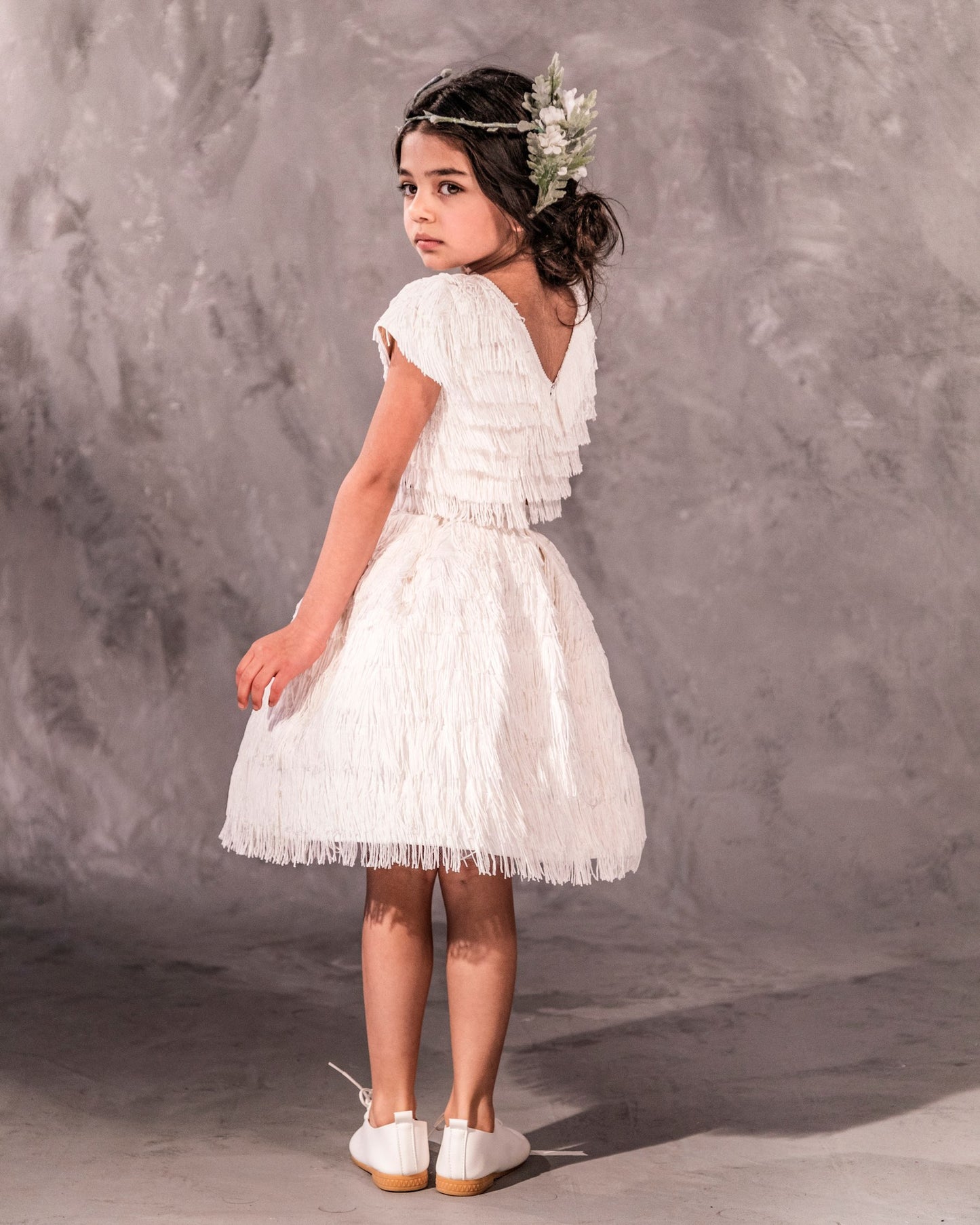 The Vera, a statement two-piece fringe ensemble featuring a cap sleeve top and separate skirt lined with soft tulle. Designed for movement with rows of silky fringe from top to bottom. Fully lined in silk with a back zip closure. Handcrafted in Brooklyn from satin, poly-blend fringe, and silk, with optional personalized embroidery. Perfect for weddings, parties, and special occasions.