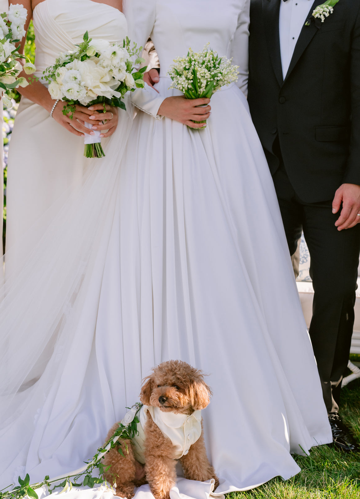 Two people in wedding attire with a dog with a bespoke wedding outfit