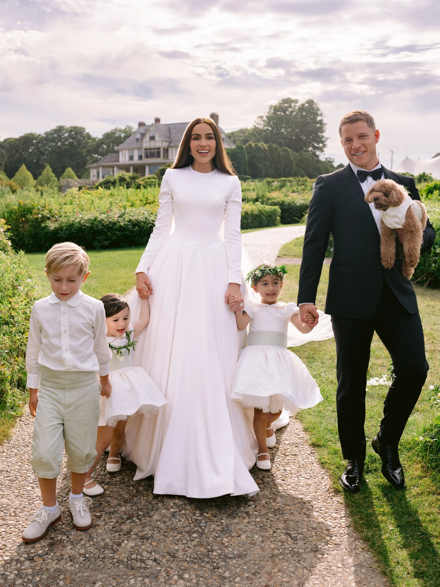 Olivia Culpo Wedding & flower girl dresses: The Rachel VIP satin flower girl dress with pleated skirt, peter pan collar, and covered buttons – elegant choice for weddings and communions.