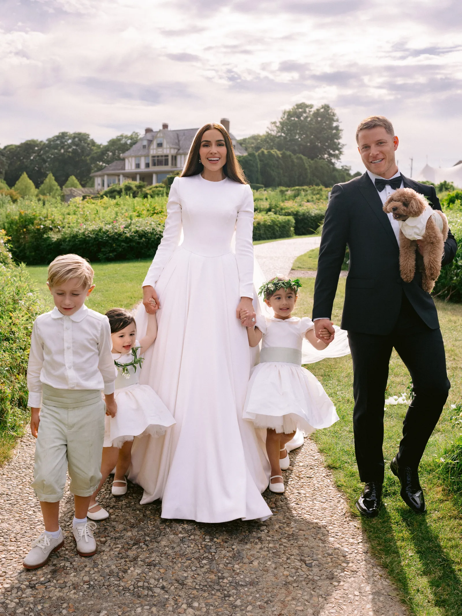 Olivia Culpo Wedding & flower girl dresses: The Rachel VIP satin flower girl dress with pleated skirt, peter pan collar, and covered buttons – elegant choice for weddings and communions.