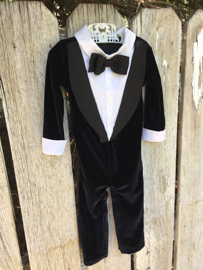 tuxedo-inspired onesie with velvet material, satin lapels, and a bow tie, for black tie and church weddings
