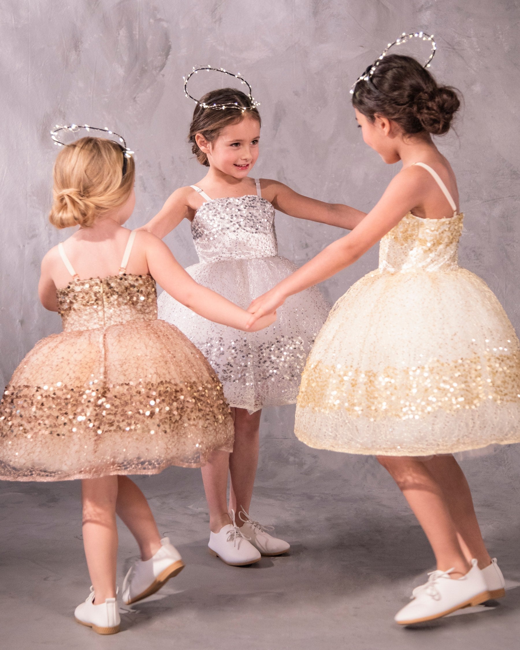 Three sparkly dresses with glittery paillettes and woven metallic threads, featuring a plush petticoat and adjustable grosgrain ribbon straps for birthday celebrations and black tie weddings