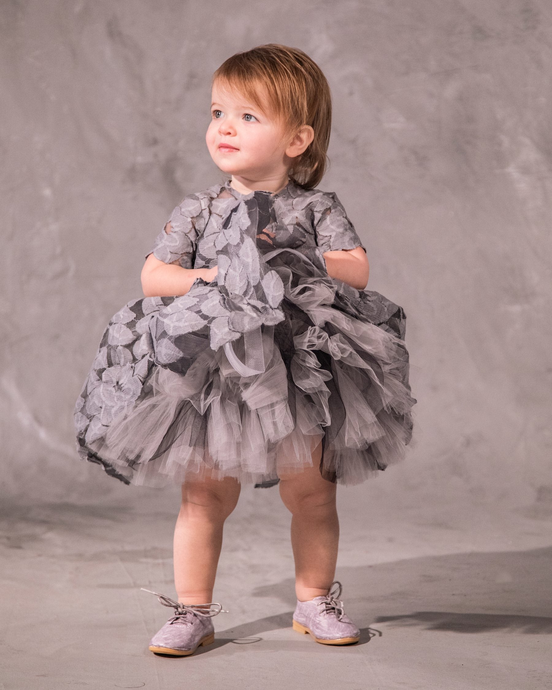 The Baby Annabelle – handcrafted cotton floral lace baby dress with a keyhole back and pearly button closure. Features a full twirl-worthy skirt, silky soft lining, and personalized embroidery. Perfect for first special occasions, weddings, communions, and celebrations