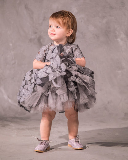 The Baby Annabelle – handcrafted cotton floral lace baby dress with a keyhole back and pearly button closure. Features a full twirl-worthy skirt, silky soft lining, and personalized embroidery. Perfect for first special occasions, weddings, communions, and celebrations