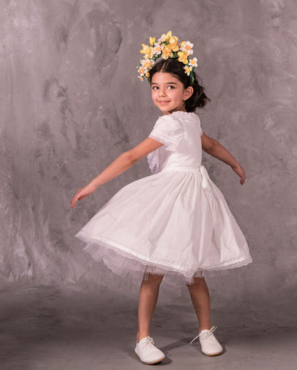 white cotton batiste flower girl dress with lace trims, short sleeves, and a knee-length skirt for summer garden wedding