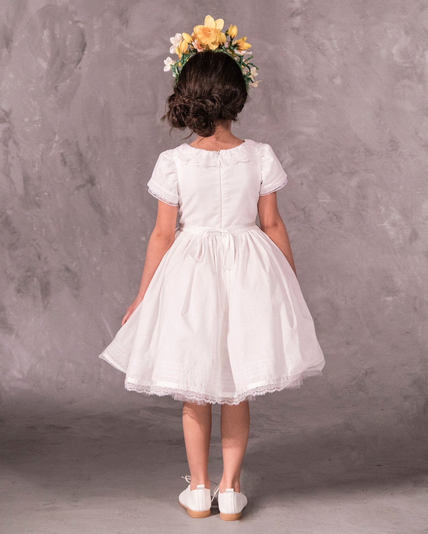 white cotton batiste flower girl dress with lace trims, short sleeves, and a knee-length skirt for summer garden wedding