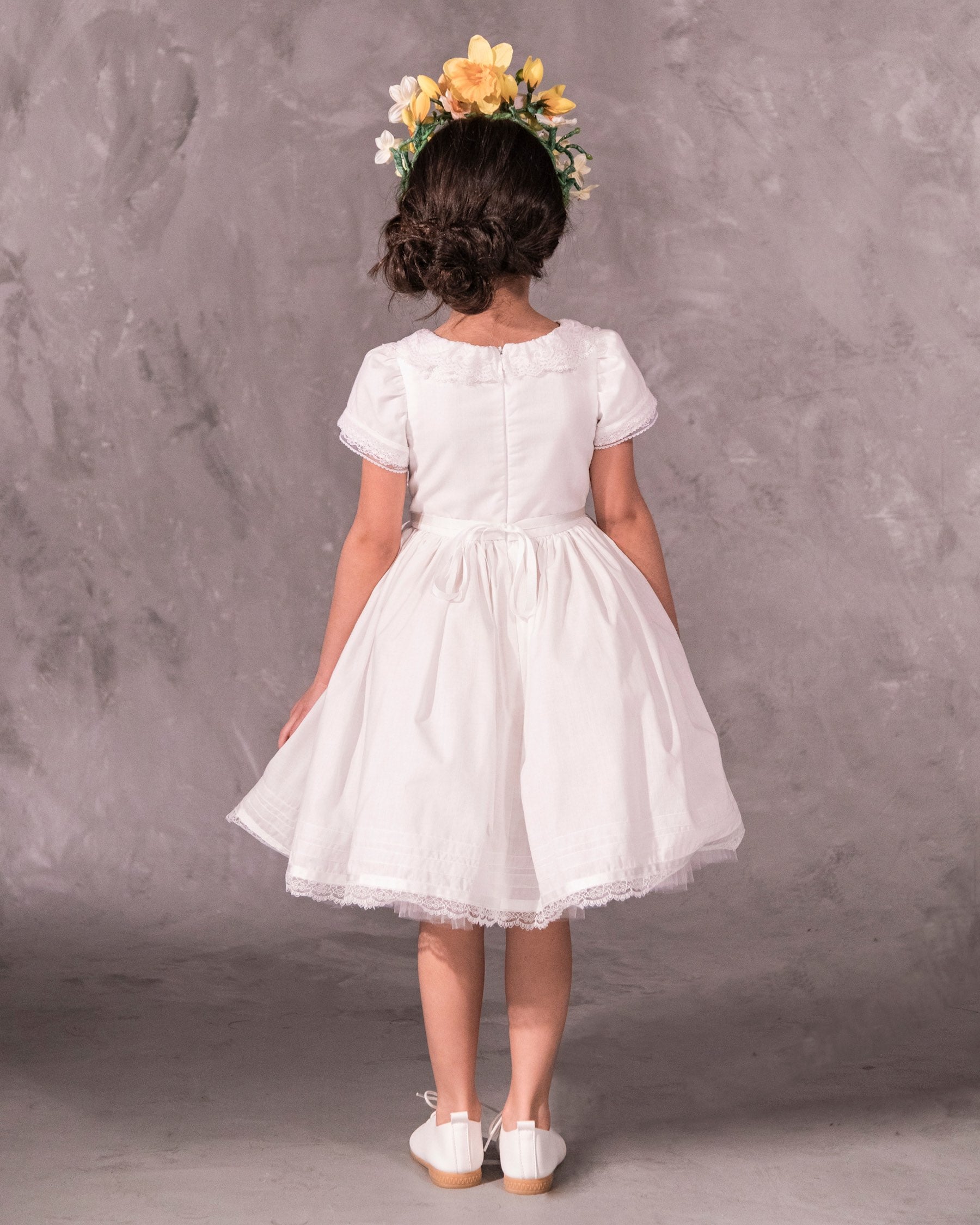 white cotton batiste flower girl dress with lace trims, short sleeves, and a knee-length skirt for summer garden wedding