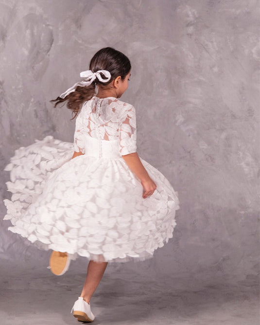 The Isabelle lace flower girl dress with 3/4 long sleeves, tea-length skirt, and pearl button back – ideal for communion and special occasions.